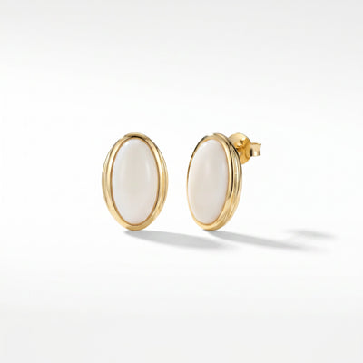 Ivory oval gold plated brass stud earrings with push-back setting on neutral surface