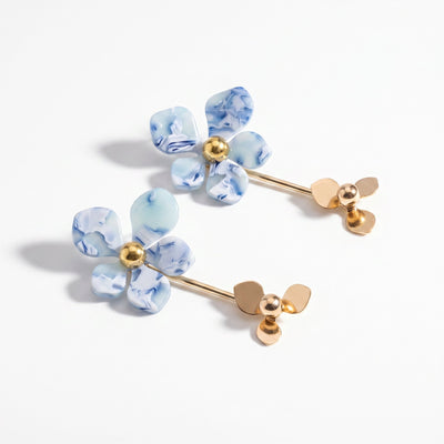 Blue marble acrylic flower drop stud earrings in gold-tone brass on clean neutral surface