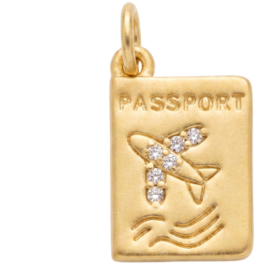 Gold brass passport charm pendant with jump ring styled on neutral surface