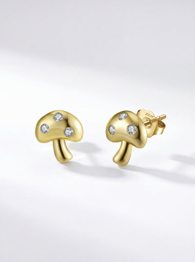 Fungia gold mushroom stud earrings on white surface in natural light