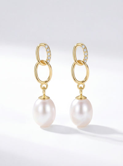 Gold freshwater pearl drop earrings with CZ accents in natural light