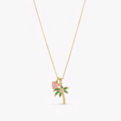 Key West-inspired gold palm tree conch pearl heart pendant necklace with green zirconia in warm natural light