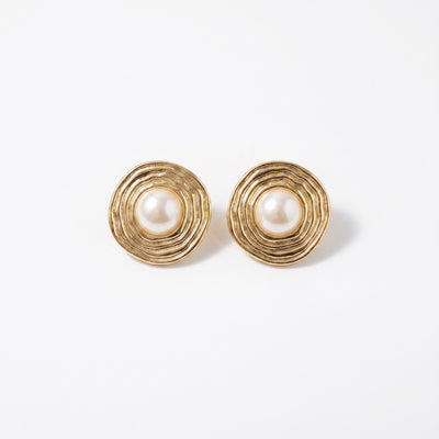 Pearl ripple bull's eye disc brass stud earrings gold tone on neutral linen surface