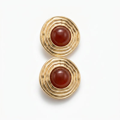 Round carnelian stud earrings in textured gold plated brass shown flat lay on light neutral surface