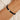 Aega Rope Bracelet worn on wrist – black rope with gold-plated CZ centerpiece, handcrafted by PRASINOUS in Key West