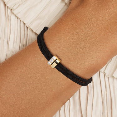 Aega Rope Bracelet worn on wrist – black rope with gold-plated CZ centerpiece, handcrafted by PRASINOUS in Key West