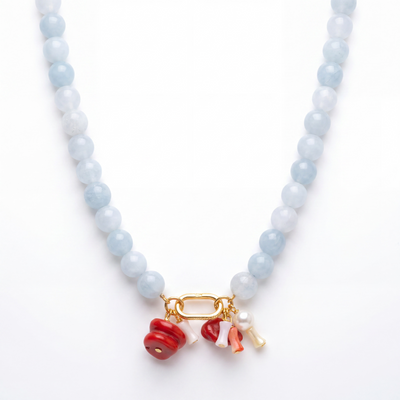 Aquamarine beaded necklace gold carabiner coral pearl charms on white background