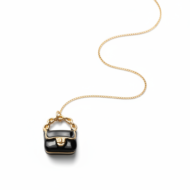 Black enamel bag charm pendant styled in soft natural light