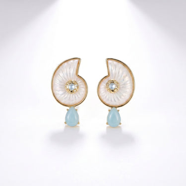 Pair of nautilus shell shaped earrings in white mother of pearl with gold trim and light blue teardrop stone drops