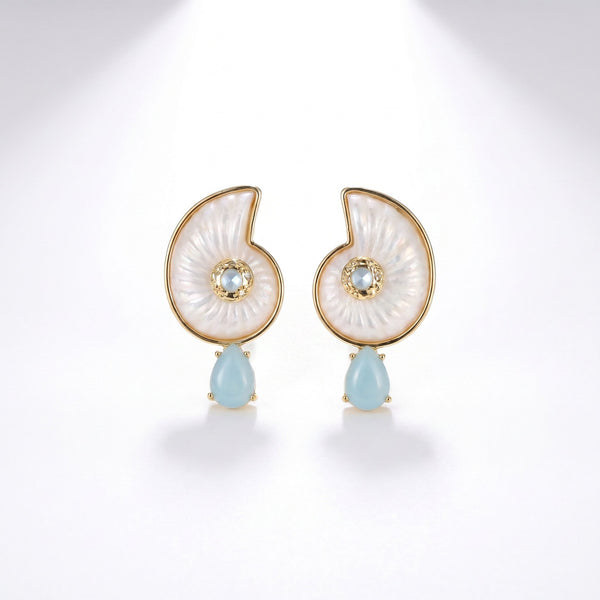 Pair of nautilus shell shaped earrings in white mother of pearl with gold trim and light blue teardrop stone drops
