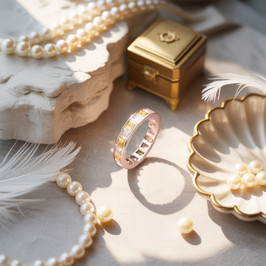 Golden hour band ring with pearls and decorative box on a textured surface