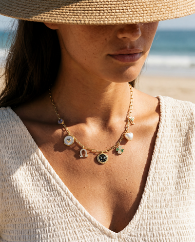 Lucky Hour charm necklace 14k gold paperclip chain seven charms on neutral background natural light