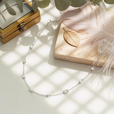 Flat lay of rhodium-plated 925 Sterling Silver Lumière Necklace sparkling under soft light