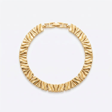 Sun Ridge gold textured bracelet by Prasinous and Coral CharmLab styled on wrist near water