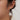 Woman wearing long chain pearl and CZ dangle earrings with pulled-back hair.