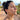 Pink and gold drop earrings with stone segments worn on a model outdoors near the ocean
