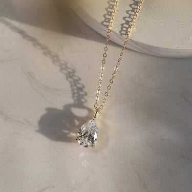 Side view of pear-cut CZ pendant in 14K gold setting.