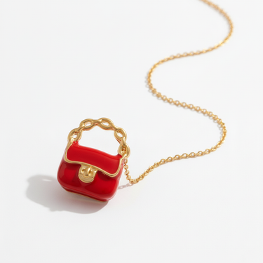 Close-up of red enamel bag charm pendant in warm natural light