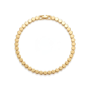 Gold plated brass honeycomb bangle bracelet with abstract geometric pattern on wrist
