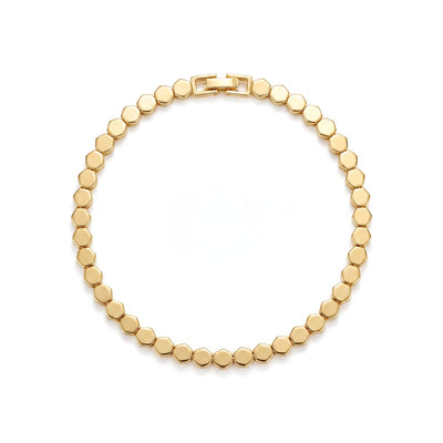 Gold plated brass honeycomb bangle bracelet with abstract geometric pattern on wrist