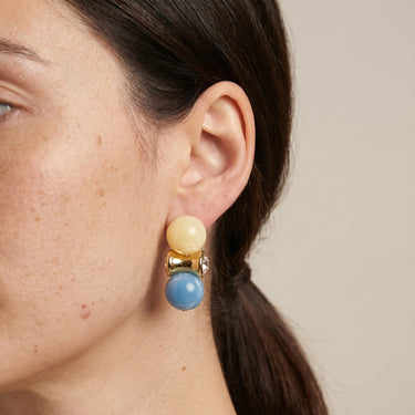Double ball drop earring with yellow and blue beads, gold connector, worn on a model
