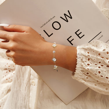 Model wearing PRASINOUS Seashell Dream Bracelet with coastal outfit.