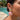 Shell drop earrings in gold brass and pink worn on a model outdoors by a pool