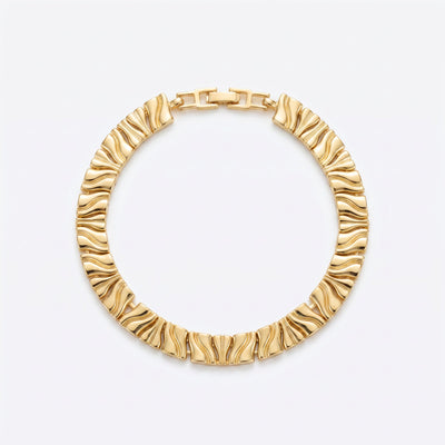 Gold-plated brass textured bracelet with raised ridges on wrist in natural light