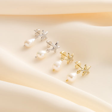 Gold and silver starfish earrings with pearls, flat lay.
