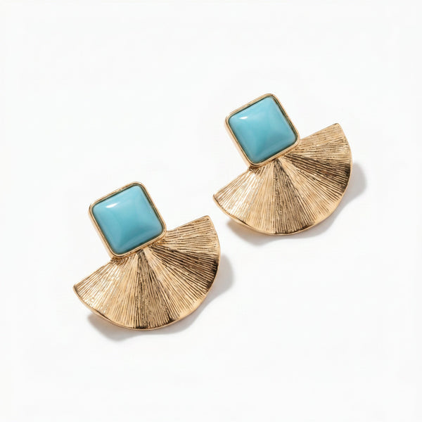 Gold tone fan shaped stud earrings with square turquoise cabochon stones, studio shot