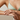 Woman wearing gold trio crystal ring and light green bikini top with a neutral background
