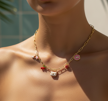Model clipping white enamel bag charm onto a handbag in natural light